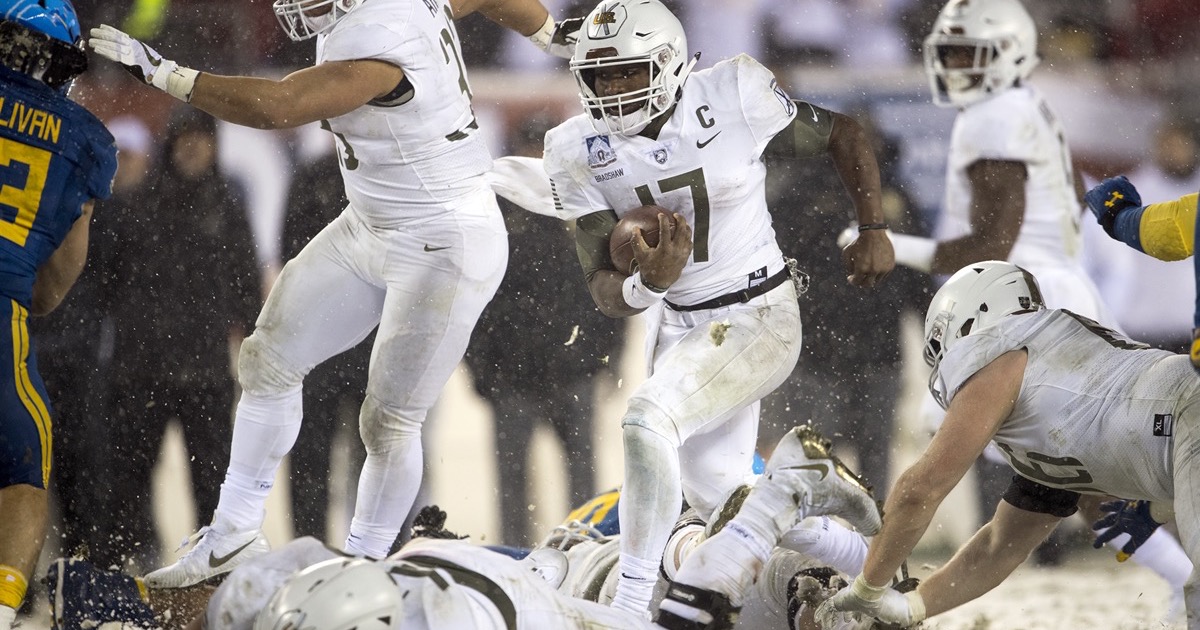 Army quarterback Ahmad Bradshaw carries the football amid falling snow against Navy in 2017